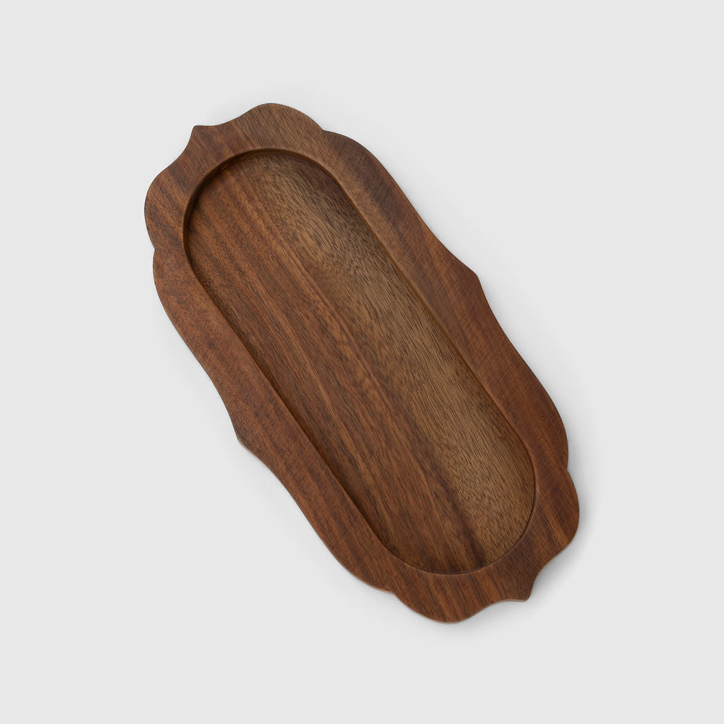 Wooden tray with scalloped edges on a white background
